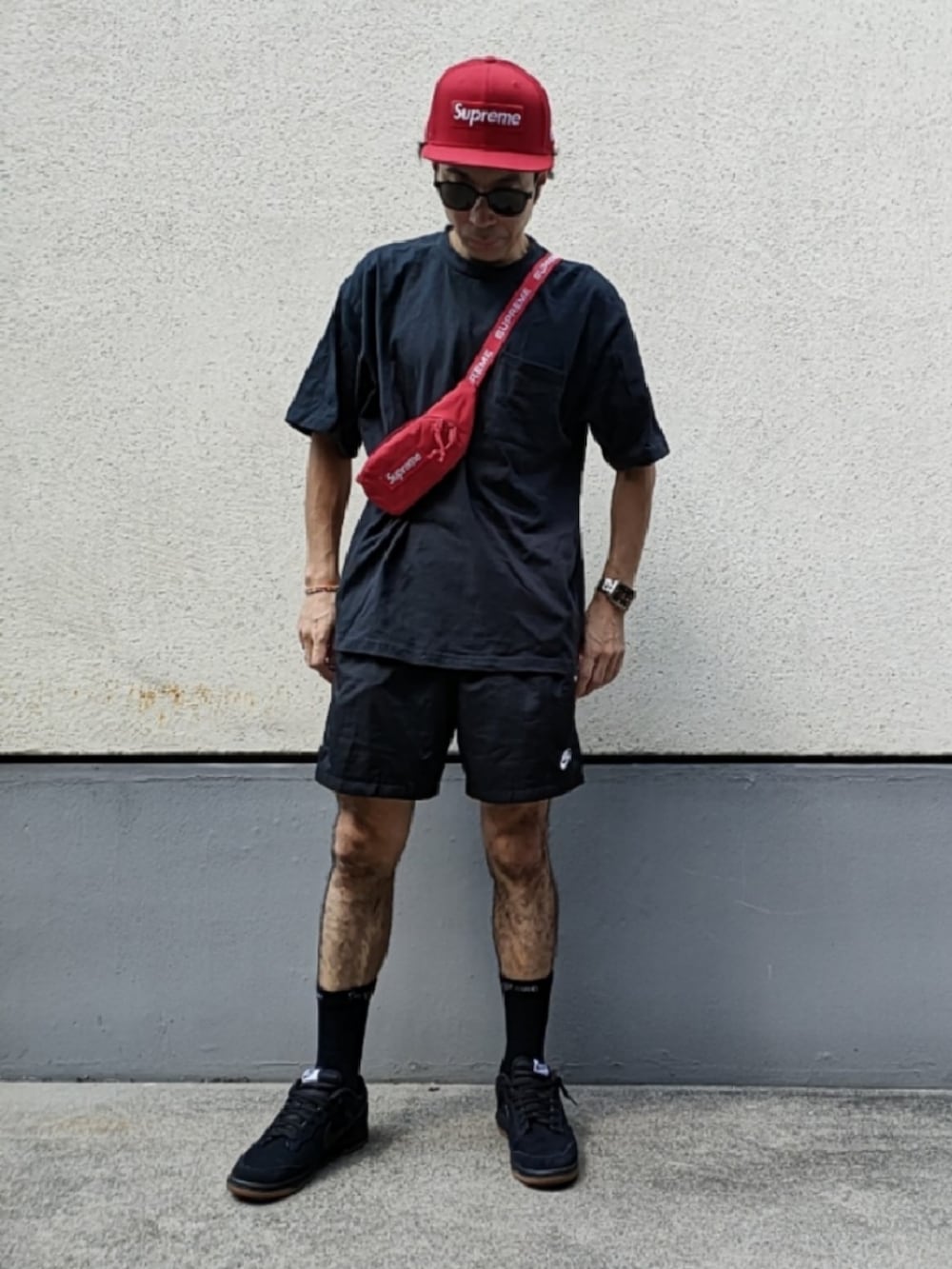 ホワイト系のTシャツ/カットソー、レッド系のボディバッグ/ウエストポーチ、ブラック系のスニーカーを着用したメンズの秋コーディネートの3枚目の写真