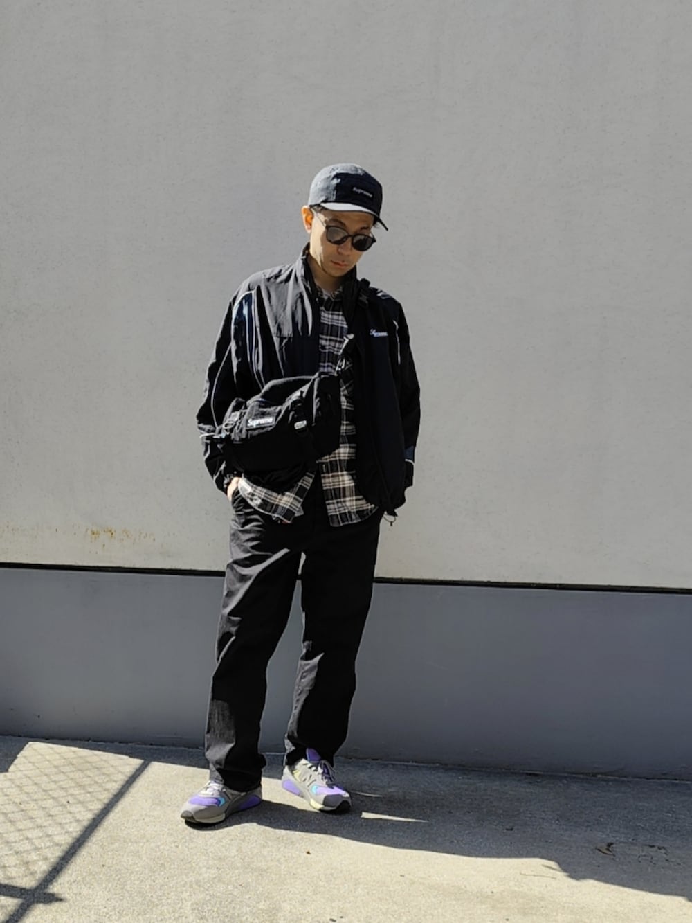 ブラック系のナイロンジャケット、グレー系のシャツ/ブラウス、ブラック系のボディバッグ/ウエストポーチを着用したメンズの春コーディネートの2枚目の写真