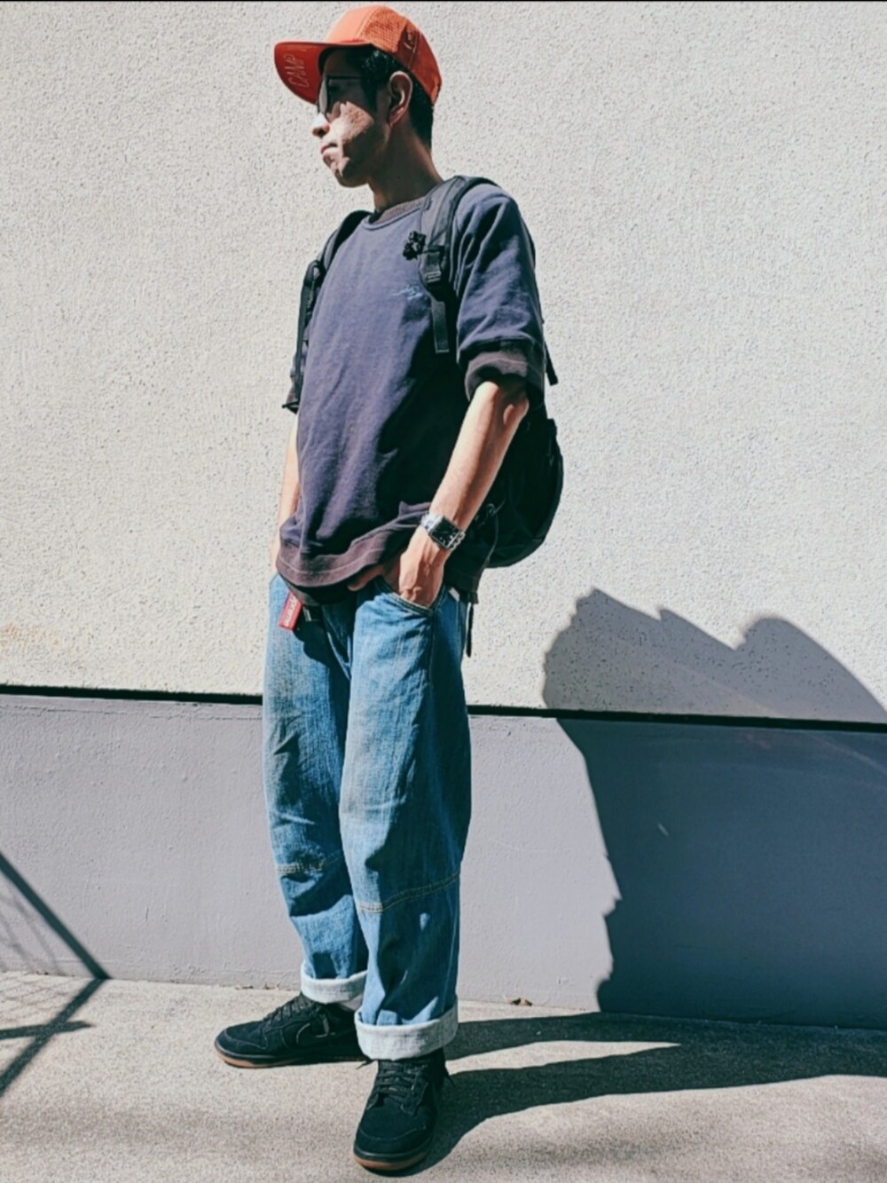 ブラック系のスウェット、ブルー系のデニムパンツ、ブラック系のスニーカーを着用したメンズの秋コーディネートの3枚目の写真