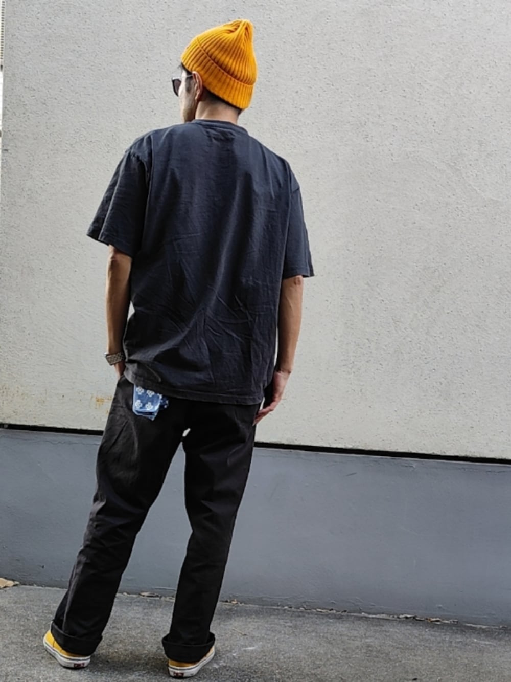ブラック系のTシャツ/カットソー、ブラック系のチノパンツ、イエロー系のスニーカーを着用したメンズの秋コーディネートの2枚目の写真
