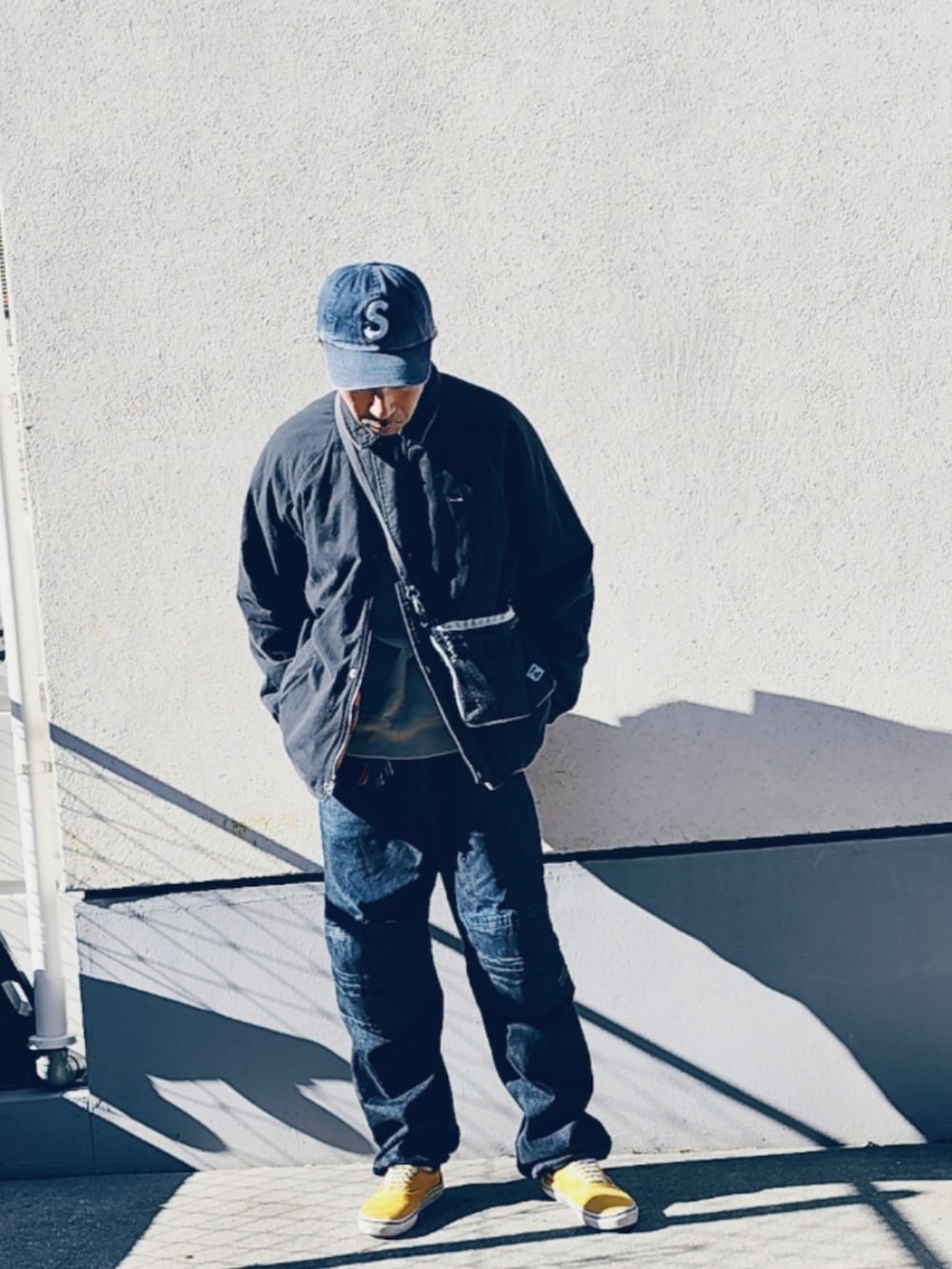 ブラック系のブルゾン、グレー系のボディバッグ/ウエストポーチ、ブラック系のデニムパンツを着用したメンズの冬コーディネートの3枚目の写真