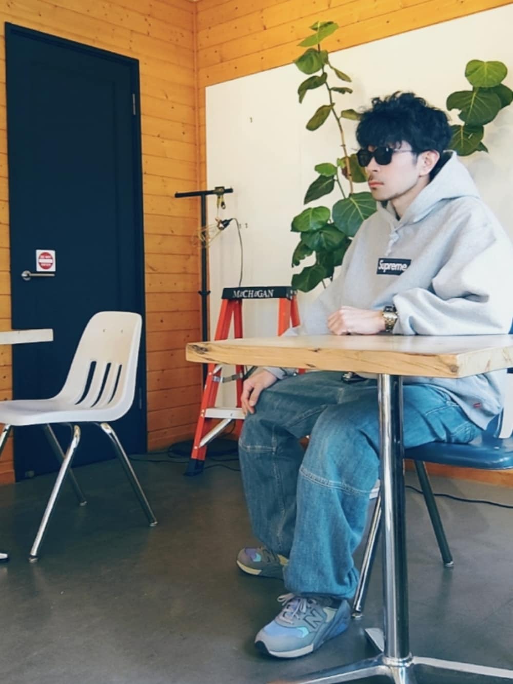 グレー系のパーカー、ブルー系のデニムパンツ、パープル系のスニーカーを着用したメンズの冬コーディネートの3枚目の写真