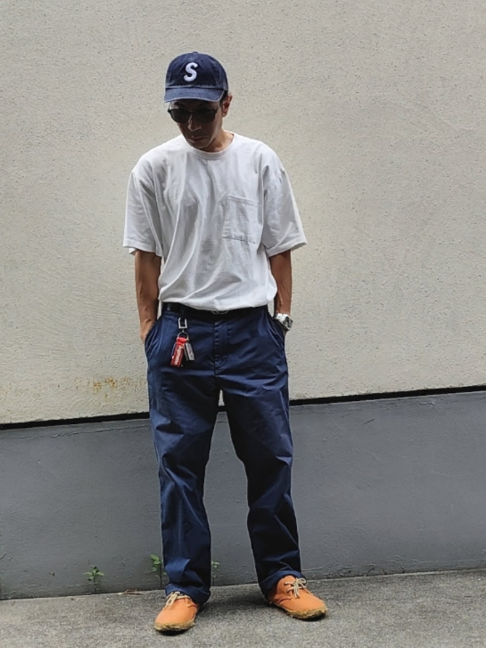 ホワイト系のTシャツ/カットソー、ブルー系のチノパンツ、オレンジ系のスニーカーを着用したメンズの夏コーディネートの2枚目の写真
