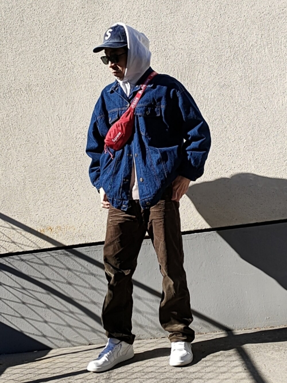 レッド系のボディバッグ/ウエストポーチ、グレー系のスウェット、ブルー系のデニムジャケットを着用したメンズの冬コーディネートの2枚目の写真