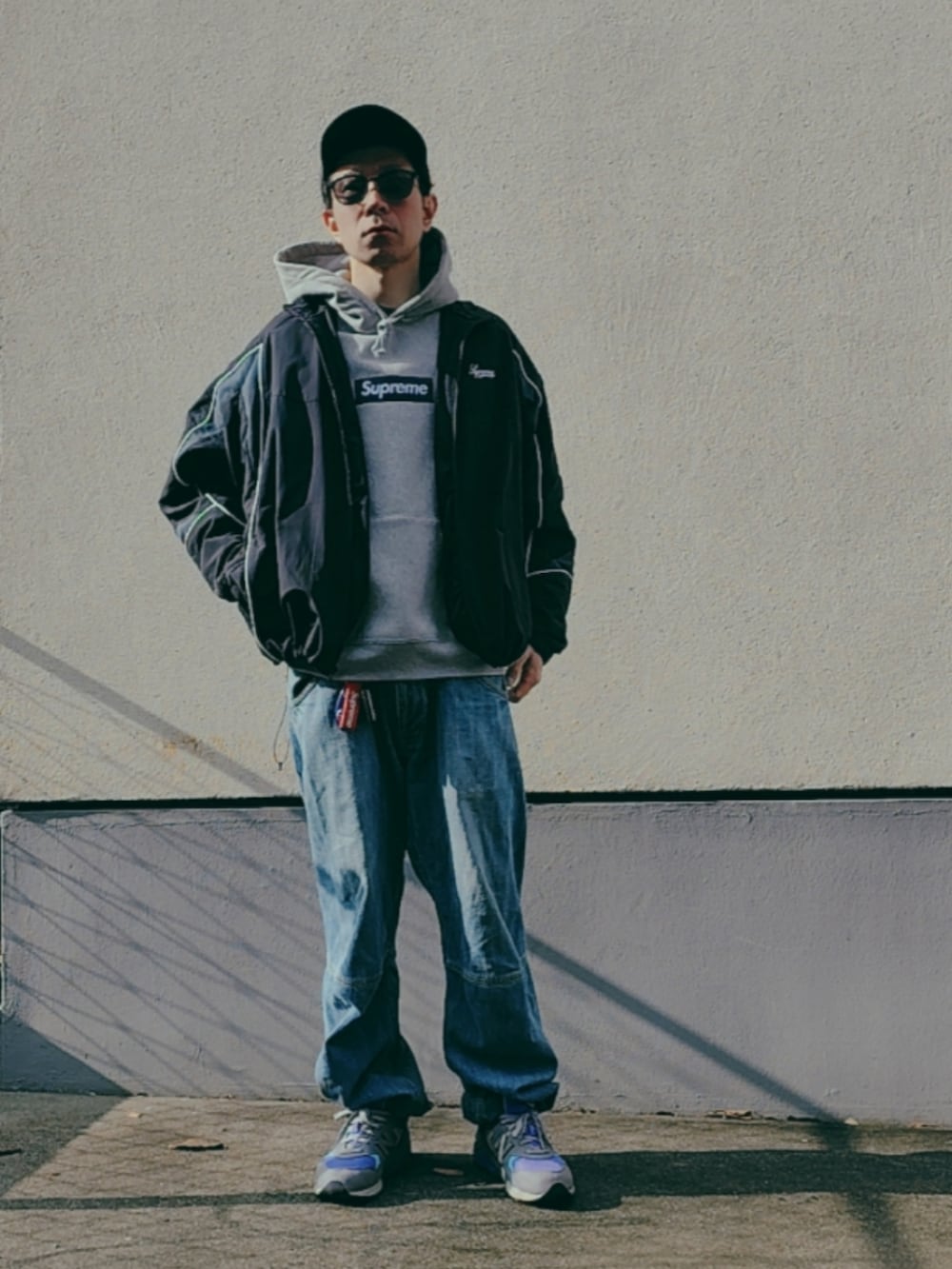 グレー系のパーカー、ブラック系のナイロンジャケット、パープル系のスニーカーを着用したメンズの冬コーディネートの3枚目の写真