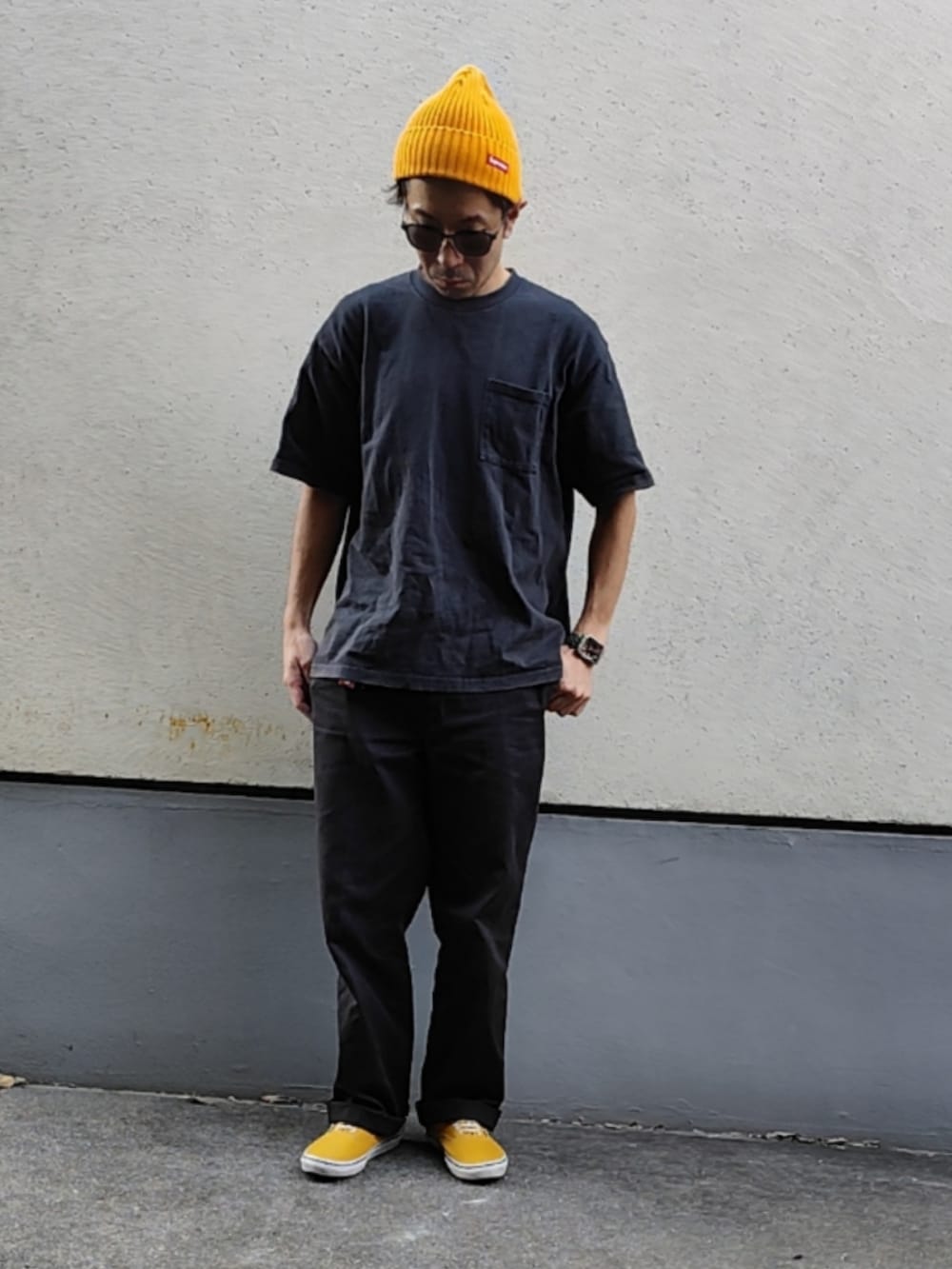 ブラック系のTシャツ/カットソー、ブラック系のチノパンツ、イエロー系のスニーカーを着用したメンズの秋コーディネートの3枚目の写真