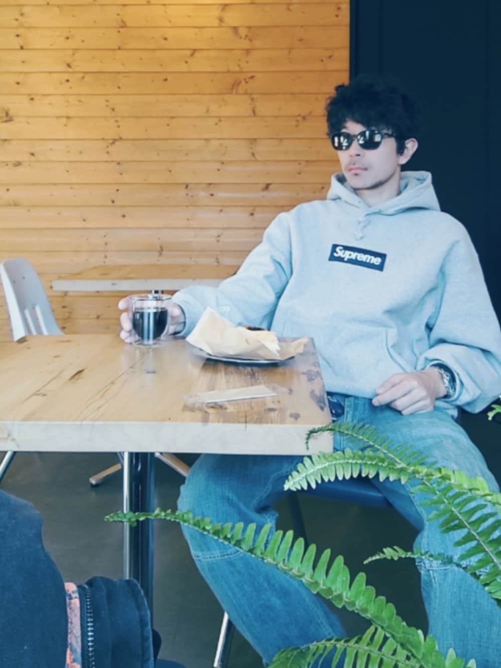 グレー系のパーカー、ブルー系のデニムパンツ、パープル系のスニーカーを着用したメンズの冬コーディネートの2枚目の写真