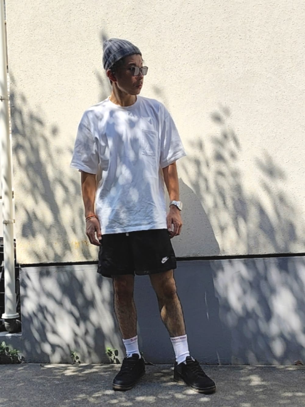 ホワイト系のTシャツ/カットソー、ブラック系のスウェットパンツ、ブラック系のスニーカーを着用したメンズの夏コーディネートの3枚目の写真