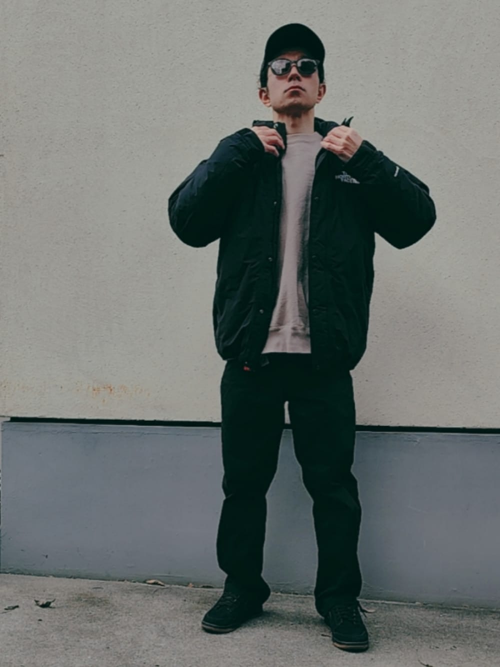 ブラック系のダウンジャケット/コート、グレー系のスウェット、ブラック系のチノパンツを着用したメンズの冬コーディネートの2枚目の写真