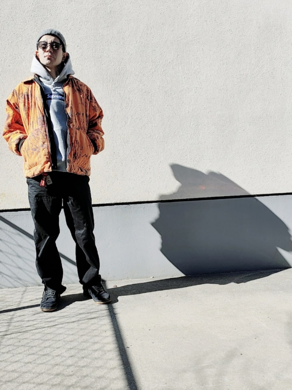 グレー系のパーカー、オレンジ系のブルゾン、ブラック系のチノパンツを着用したメンズの冬コーディネートの4枚目の写真