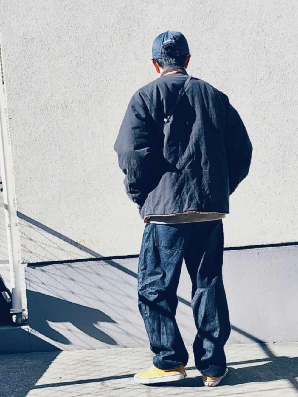 ブラック系のブルゾン、グレー系のボディバッグ/ウエストポーチ、ブラック系のデニムパンツを着用したメンズの冬コーディネートの2枚目の写真