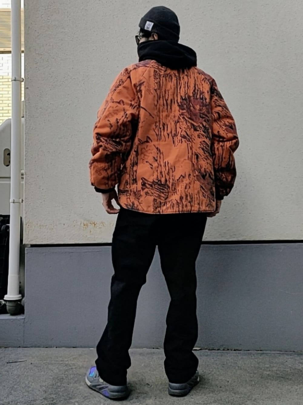 ブラック系のパーカー、ブラック系のチノパンツ、パープル系のスニーカーを着用したメンズの冬コーディネートの2枚目の写真