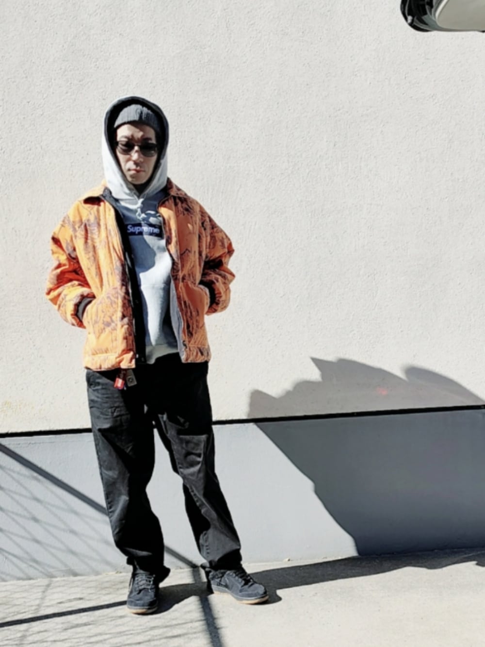 グレー系のパーカー、オレンジ系のブルゾン、ブラック系のチノパンツを着用したメンズの冬コーディネートの2枚目の写真