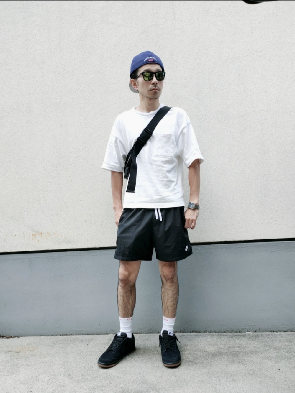 ブラック系のその他パンツ、ブラック系のボディバッグ/ウエストポーチ、ホワイト系のTシャツ/カットソーを着用したメンズの夏コーディネートの3枚目の写真