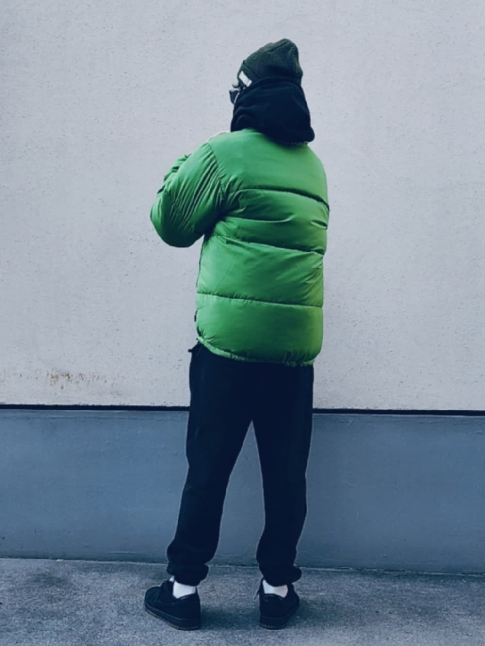 グリーン系のダウンジャケット/コート、ブラック系のパーカー、ブラック系のスウェットパンツを着用したメンズの冬コーディネートの3枚目の写真