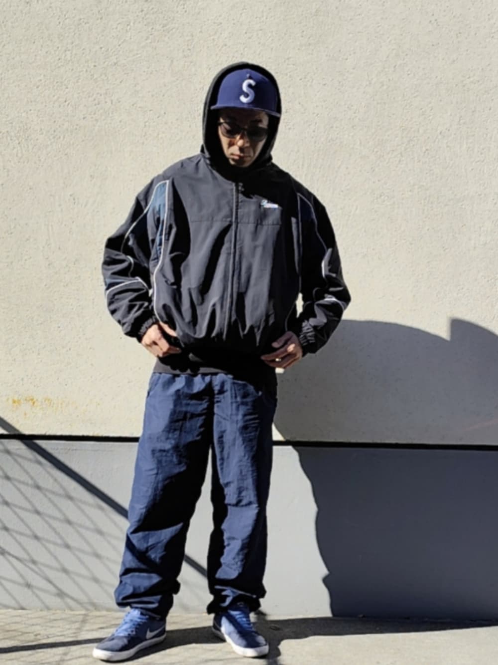 ブラック系のパーカー、ブラック系のナイロンジャケット、ブルー系のその他パンツを着用したメンズの冬コーディネートの3枚目の写真