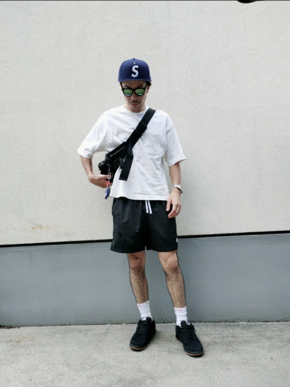 ブラック系のその他パンツ、ブラック系のボディバッグ/ウエストポーチ、ホワイト系のTシャツ/カットソーを着用したメンズの夏コーディネートの2枚目の写真