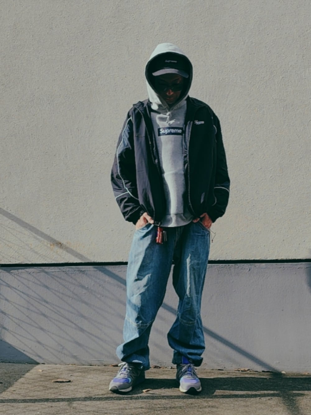 グレー系のパーカー、ブラック系のナイロンジャケット、パープル系のスニーカーを着用したメンズの冬コーディネートの4枚目の写真