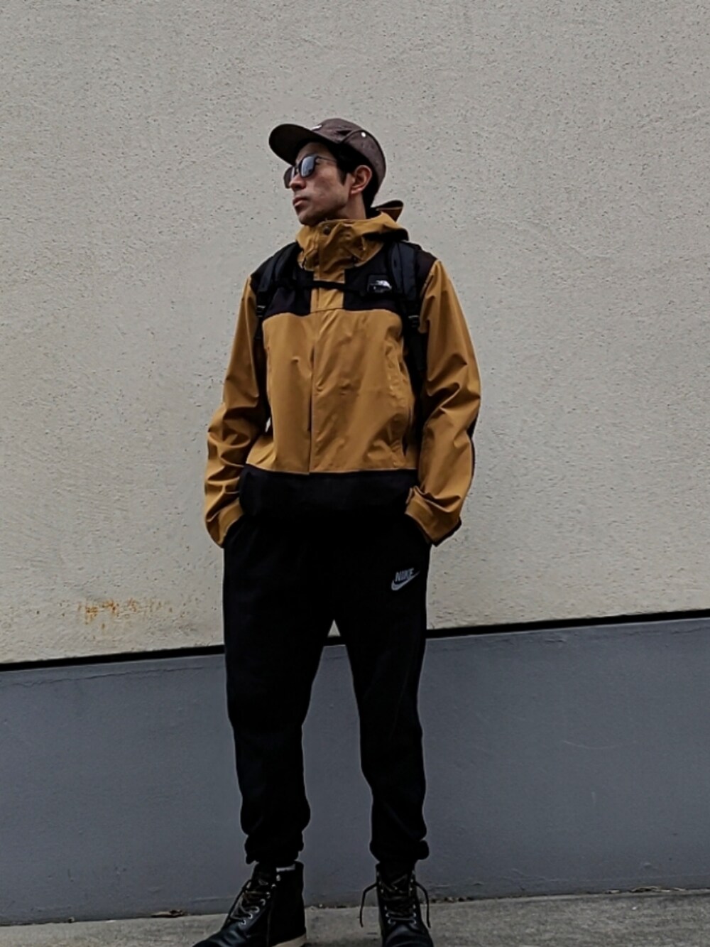 ベージュ系のマウンテンパーカー、ブラック系のスウェットパンツ、ブラック系のブーツを着用したメンズの冬コーディネートの2枚目の写真