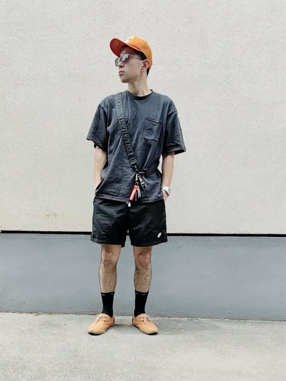 ホワイト系のTシャツ/カットソー、ブラック系のその他パンツ、オレンジ系のスニーカーを着用したメンズの春コーディネートの2枚目の写真