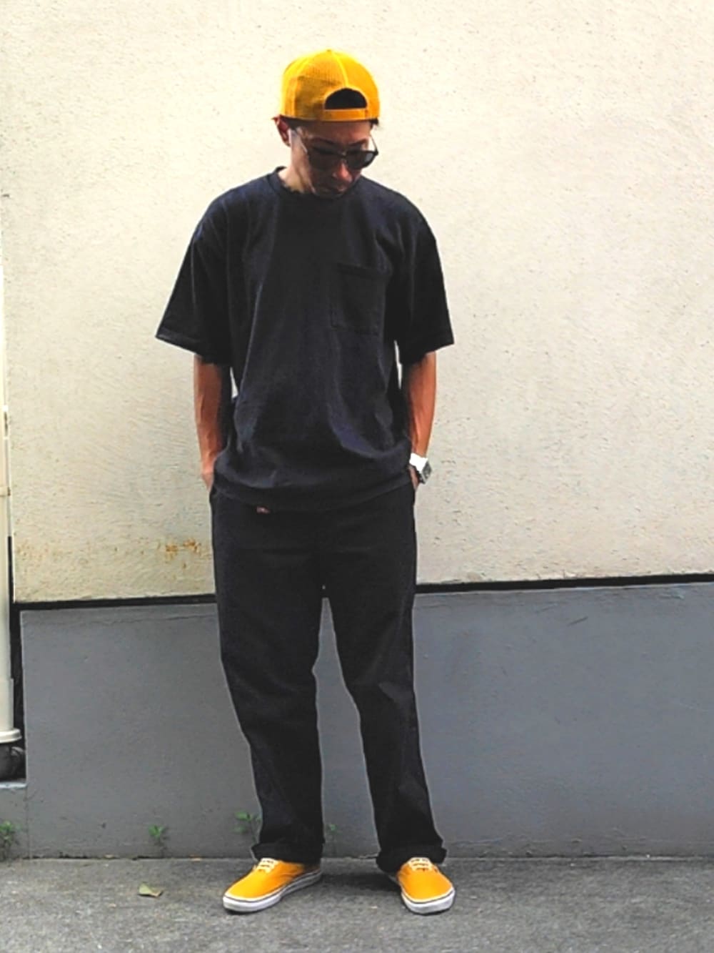 ブラック系のTシャツ/カットソー、ブラック系のチノパンツ、イエロー系のスニーカーを着用したメンズの夏コーディネートの3枚目の写真