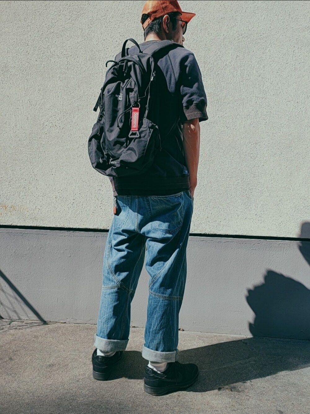 ブラック系のスウェット、ブルー系のデニムパンツ、ブラック系のスニーカーを着用したメンズの秋コーディネートの2枚目の写真