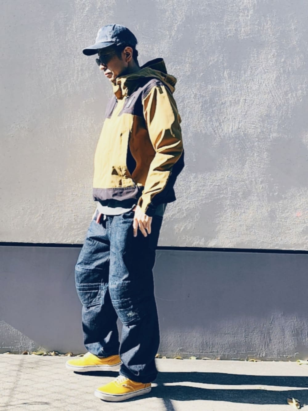 ブラック系のデニムパンツ、イエロー系のスニーカー、ブラック系のスウェットを着用したメンズの秋コーディネートの3枚目の写真