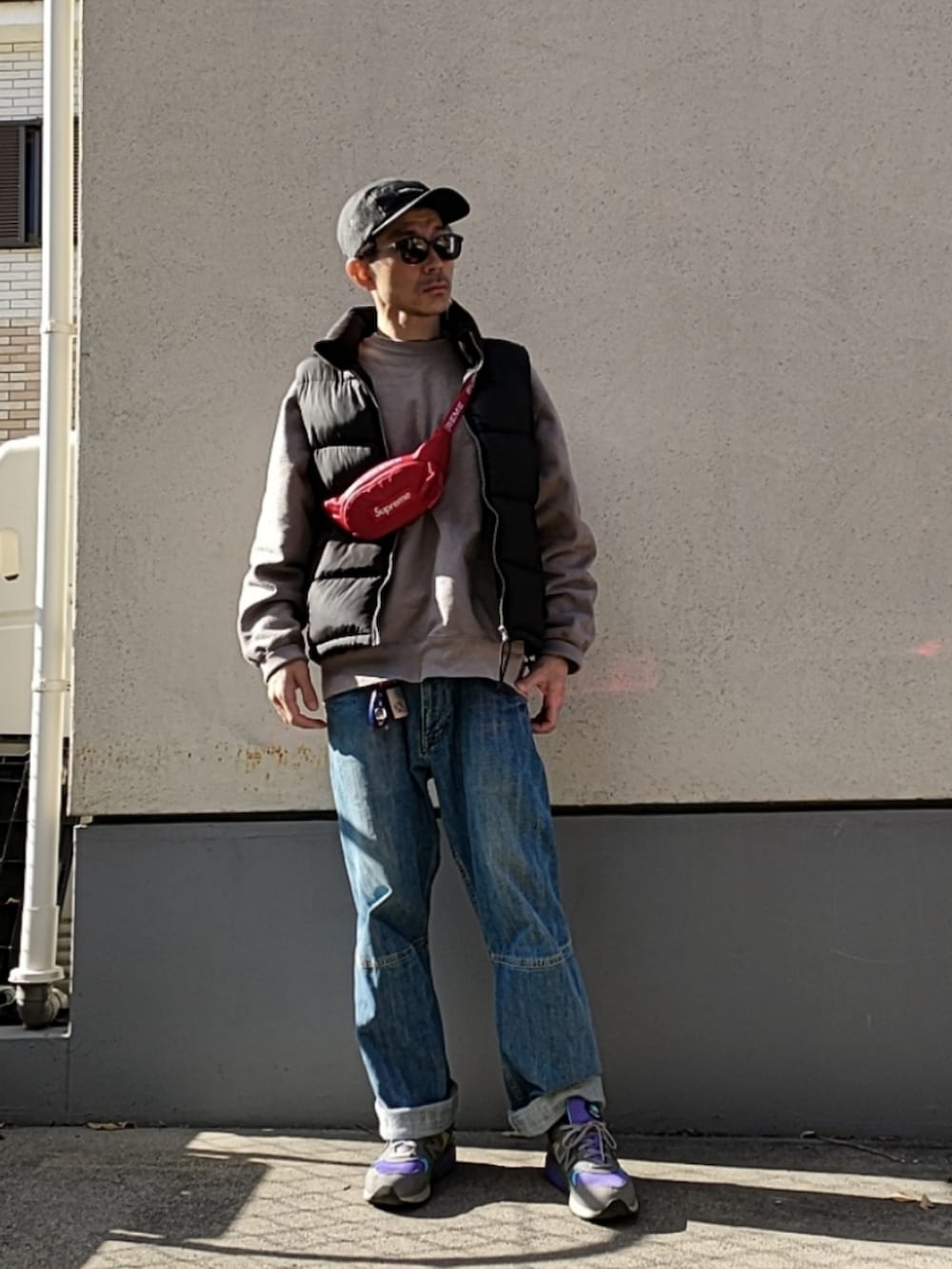 ブルー系のデニムパンツ、パープル系のスニーカー、グレー系のスウェットを着用したメンズの冬コーディネートの2枚目の写真