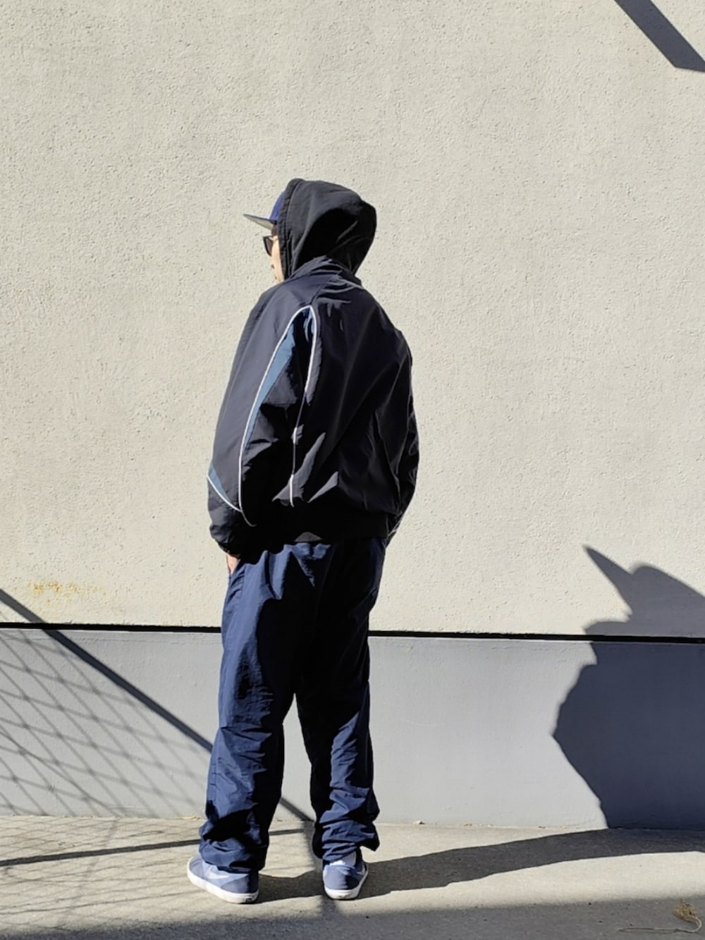 ブラック系のパーカー、ブラック系のナイロンジャケット、ブルー系のその他パンツを着用したメンズの冬コーディネートの2枚目の写真