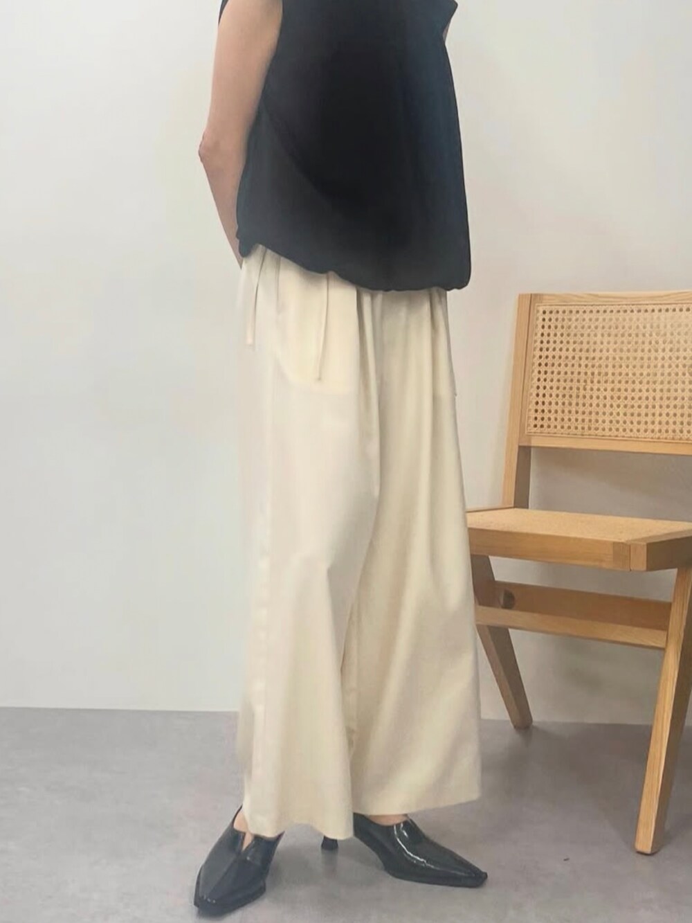 ブラック系のパンプス、ホワイト系のその他パンツを着用したレディースの秋コーディネートの3枚目の写真