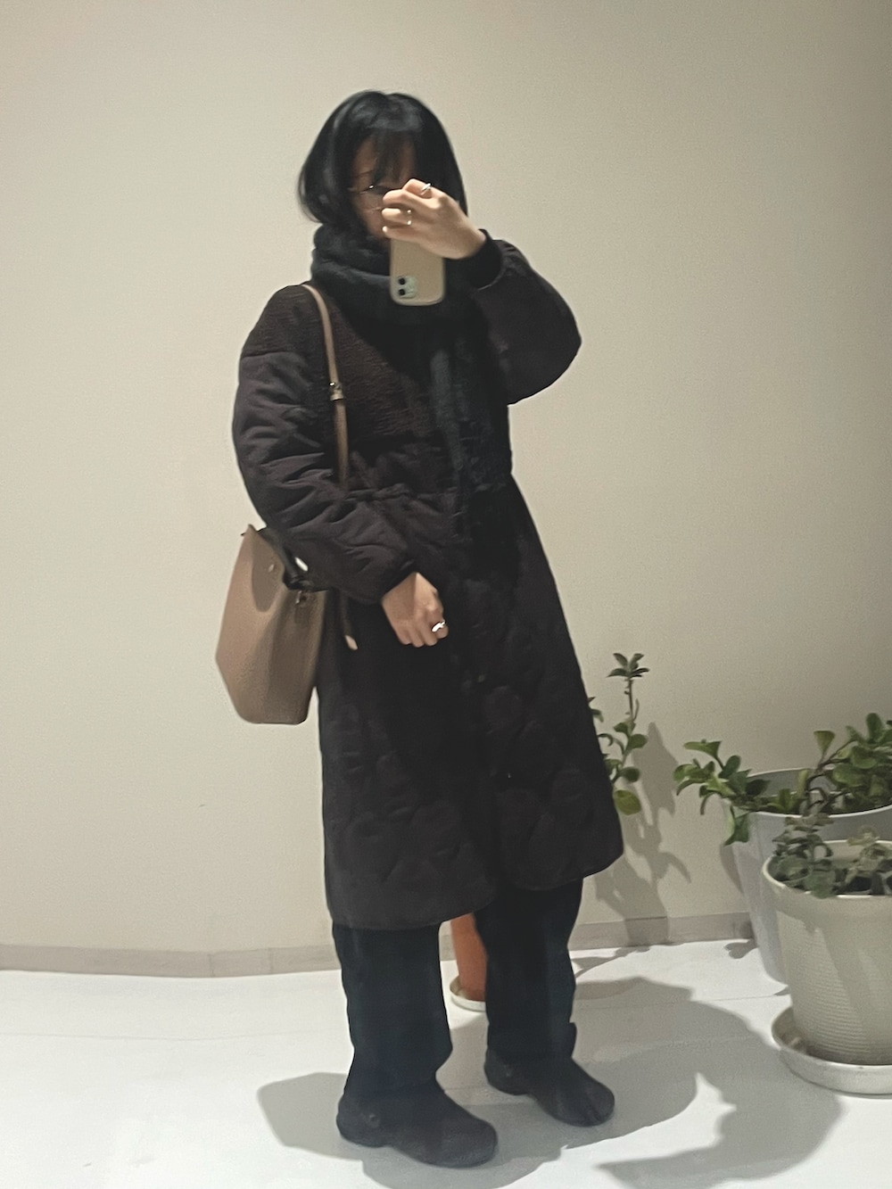 ブラウン系のノーカラーコート、ブラウン系のノーカラーコート、ブラウン系のサンダルを着用したレディースの冬コーディネートの3枚目の写真