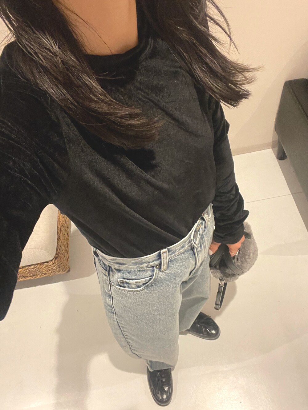 ブラック系のスニーカー、グレー系のショルダーバッグ、ブルー系のデニムパンツを着用したレディースの秋コーディネートの2枚目の写真