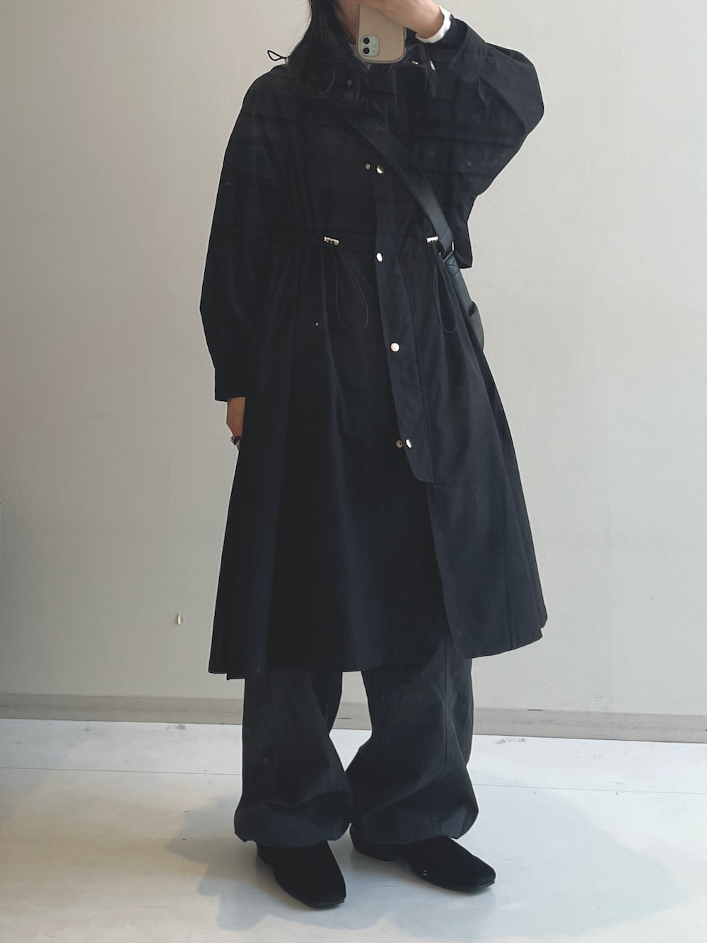 ブラック系のブーツ、ブラック系のショルダーバッグ、ブラック系のモッズコートを着用したレディースの冬コーディネートの6枚目の写真