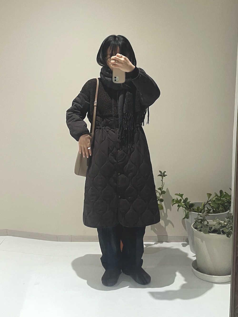 ブラウン系のノーカラーコート、ブラウン系のノーカラーコート、ブラウン系のサンダルを着用したレディースの冬コーディネートの2枚目の写真