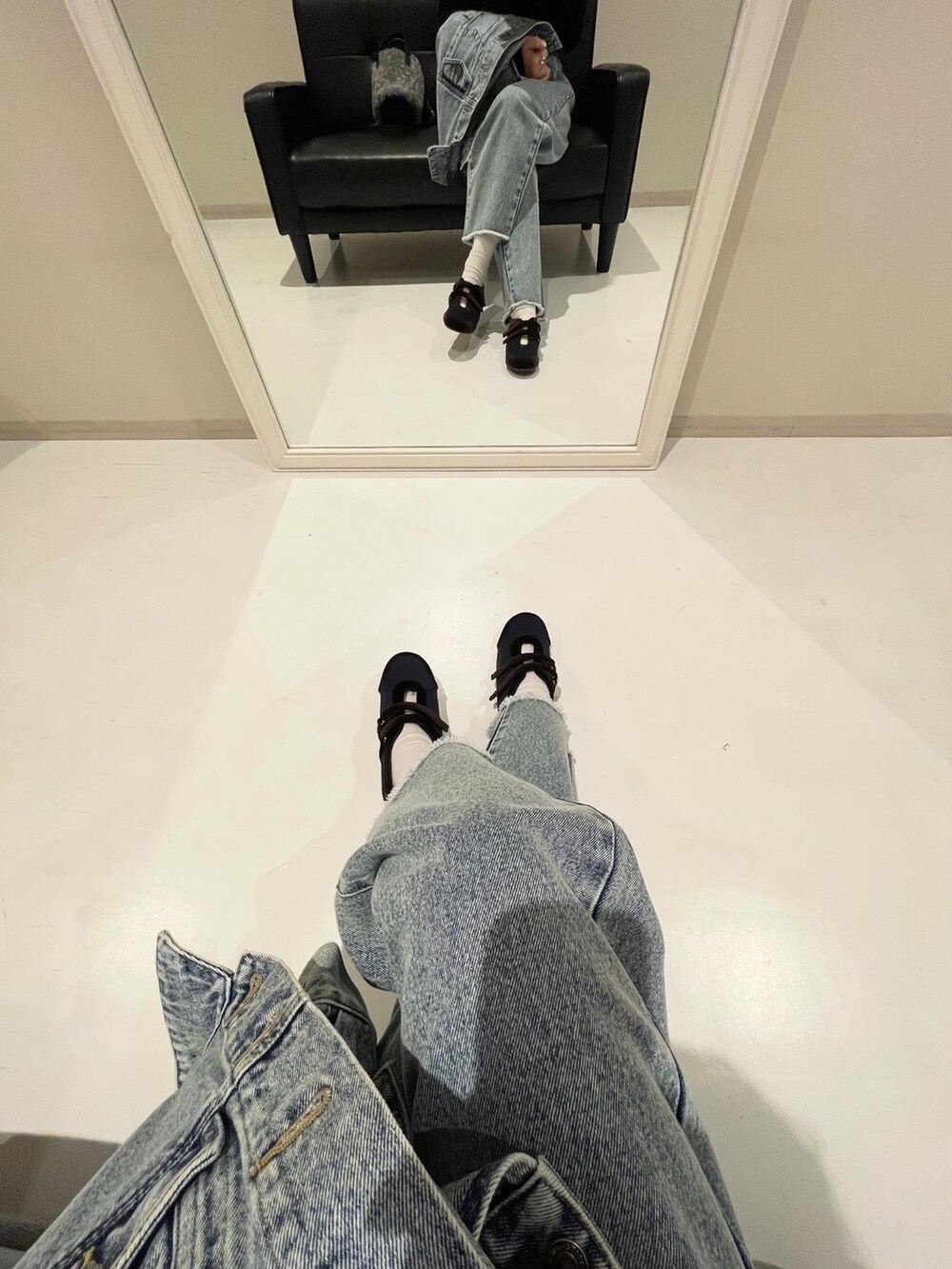 グレー系のショルダーバッグ、ブルー系のデニムパンツ、ブルー系のデニムジャケットを着用したレディースの秋コーディネートの2枚目の写真