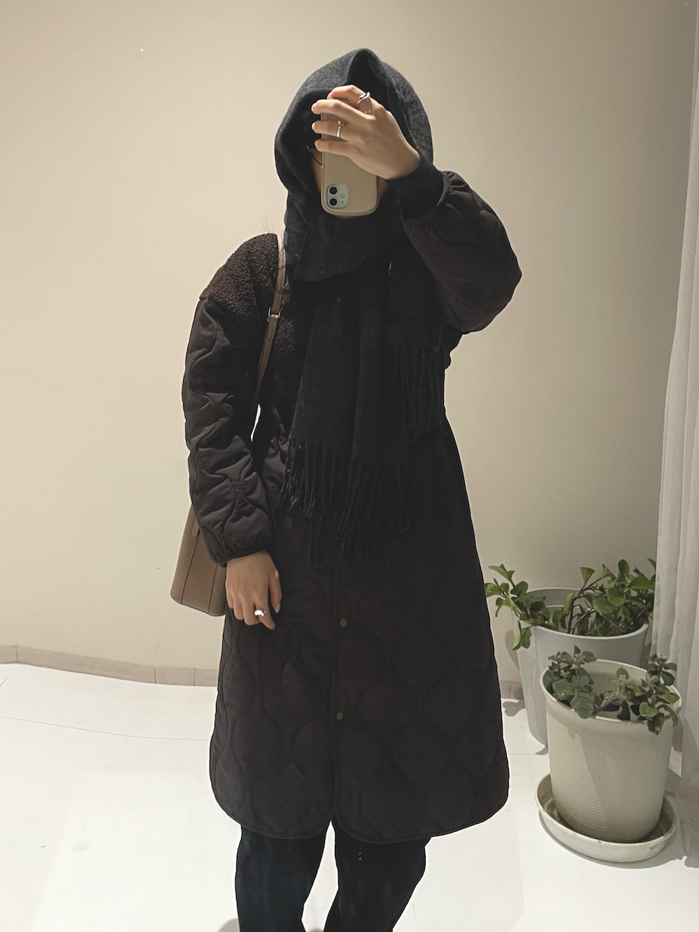 ブラウン系のノーカラーコート、ブラウン系のノーカラーコート、ブラウン系のサンダルを着用したレディースの冬コーディネートの10枚目の写真