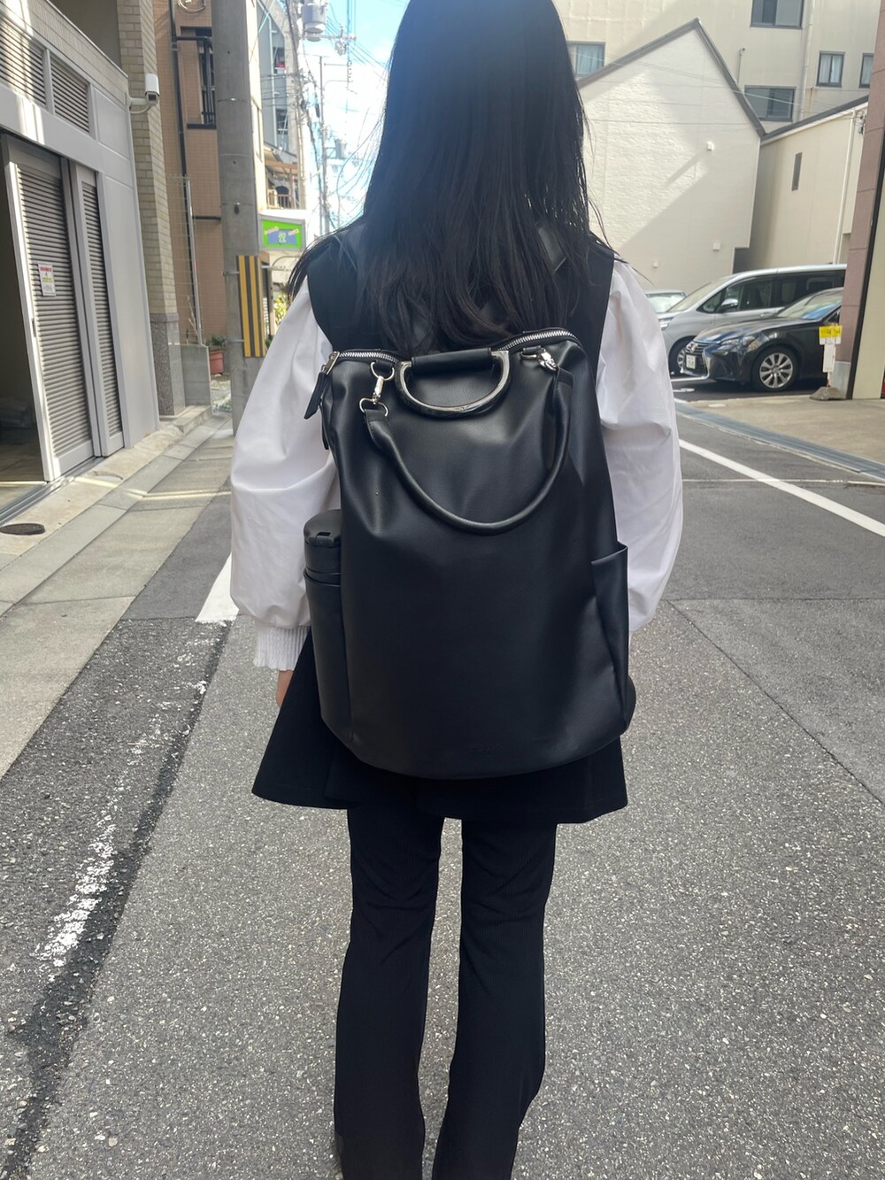 ブラック系のバックパック/リュック、ブラック系のパンプスを着用したレディースの秋コーディネートの2枚目の写真