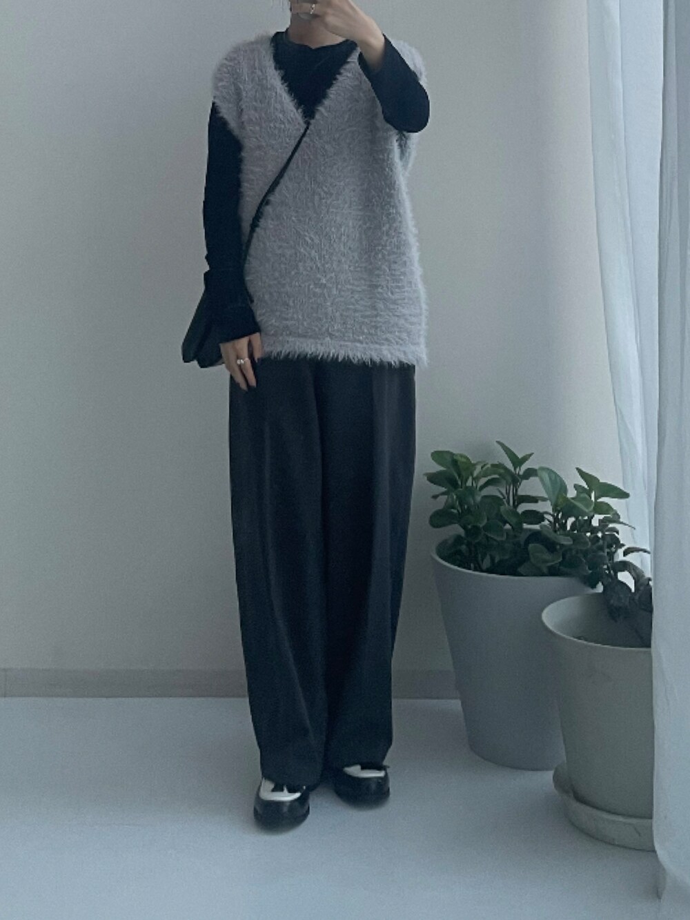 グレー系のニット/セーター、ブラック系のスニーカーを着用したレディースの秋コーディネートの2枚目の写真