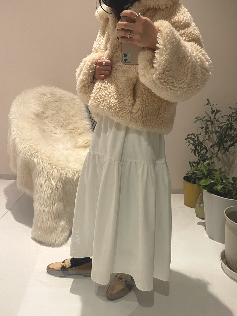 グレー系のショルダーバッグ、ホワイト系のスカート、ホワイト系のスカートを着用したレディースの冬コーディネートの3枚目の写真