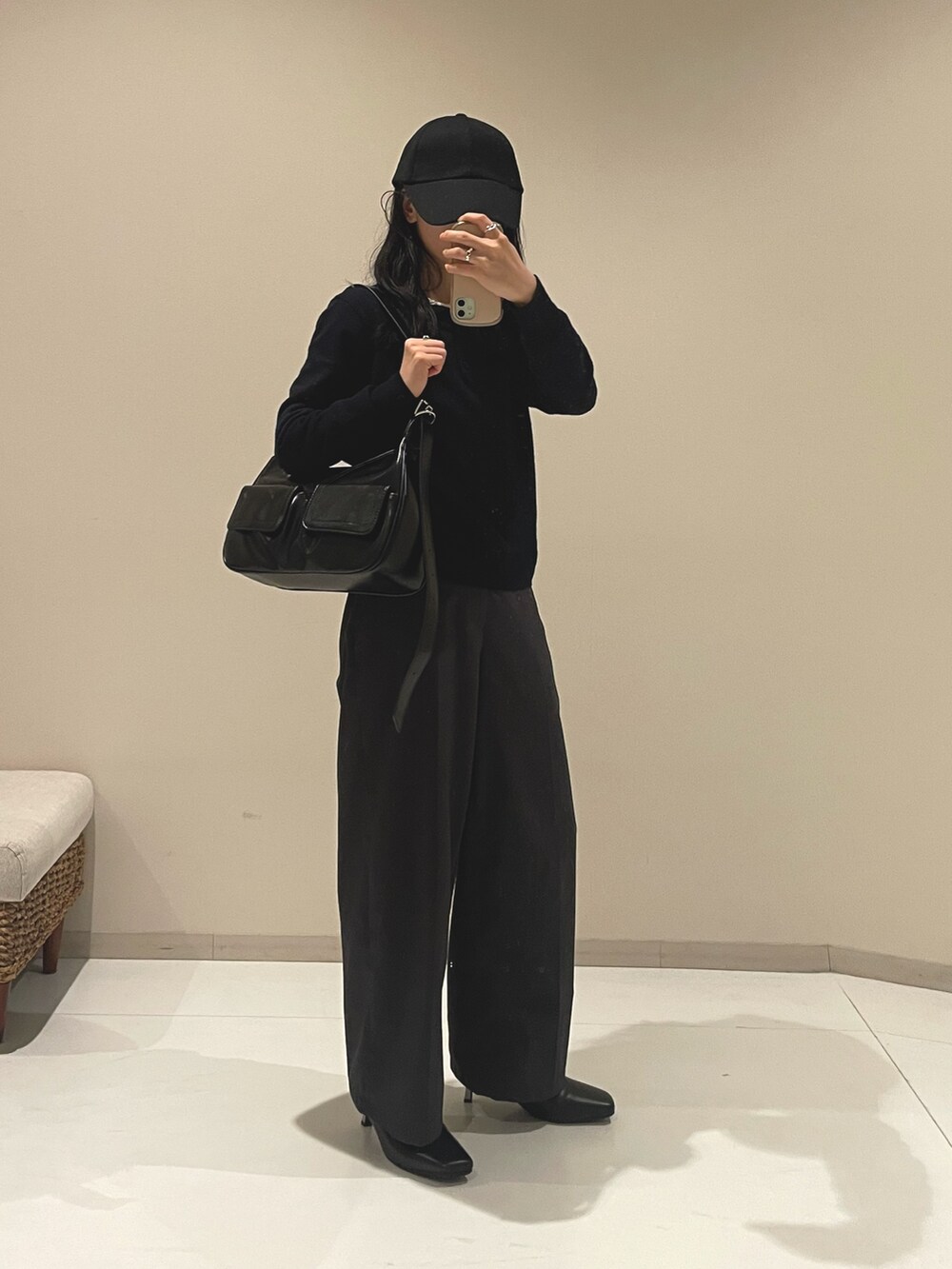 ブラウン系のブーツ、ブラック系のショルダーバッグ、ブラック系のキャップを着用したレディースの秋コーディネートの2枚目の写真