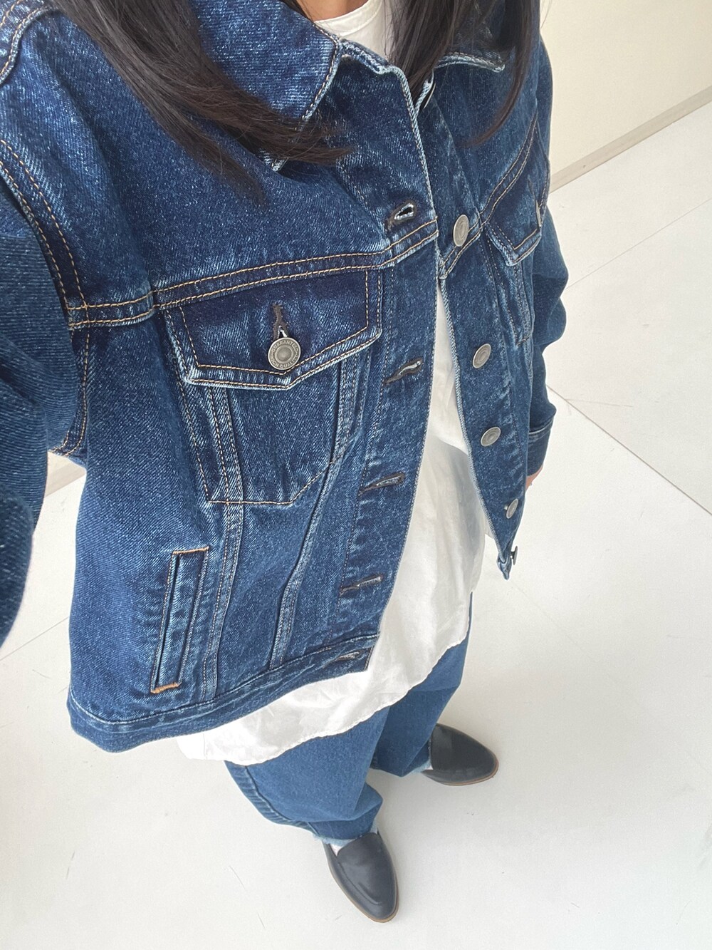 ブラック系のバレエシューズ、ブルー系のデニムパンツ、ブルー系のデニムジャケットを着用したレディースの秋コーディネートの2枚目の写真