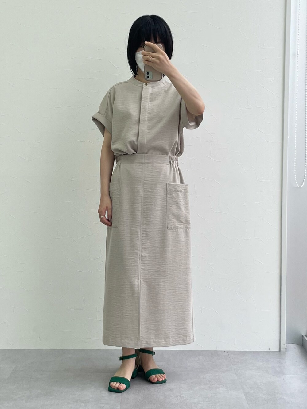 ベージュ系のシャツ/ブラウス、ベージュ系のスカート、グリーン系のサンダルを着用したレディースの夏コーディネートの2枚目の写真
