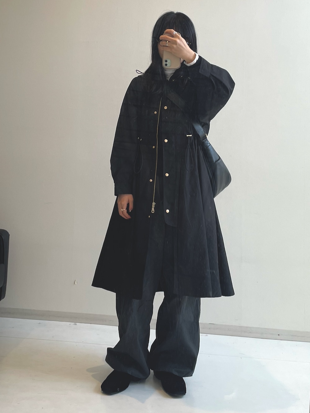 ブラック系のブーツ、ブラック系のショルダーバッグ、ブラック系のモッズコートを着用したレディースの冬コーディネートの4枚目の写真