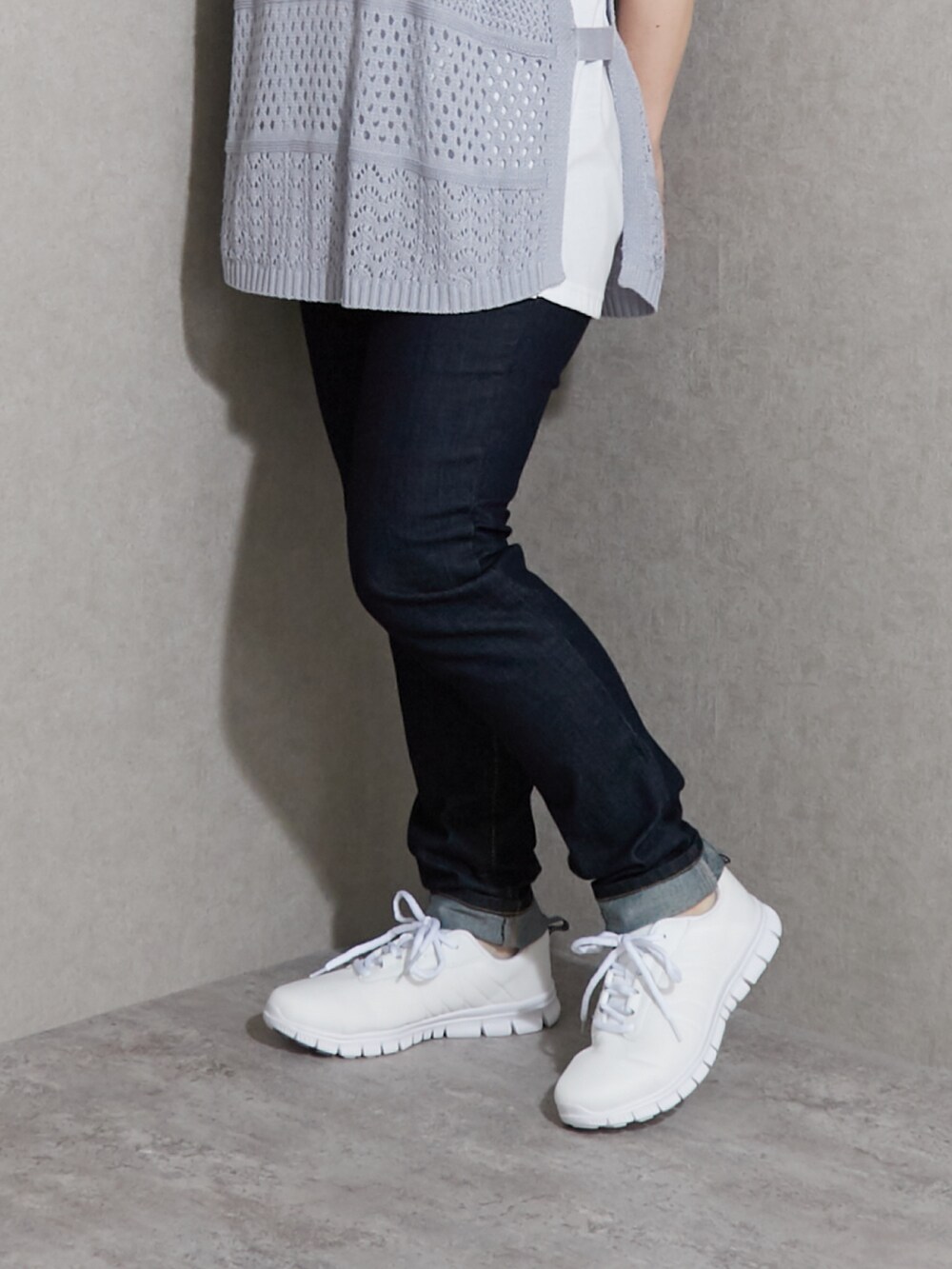 グレー系のスニーカー、ブルー系のデニムパンツ、ブルー系のニット/セーターを着用したレディースの夏コーディネートの4枚目の写真