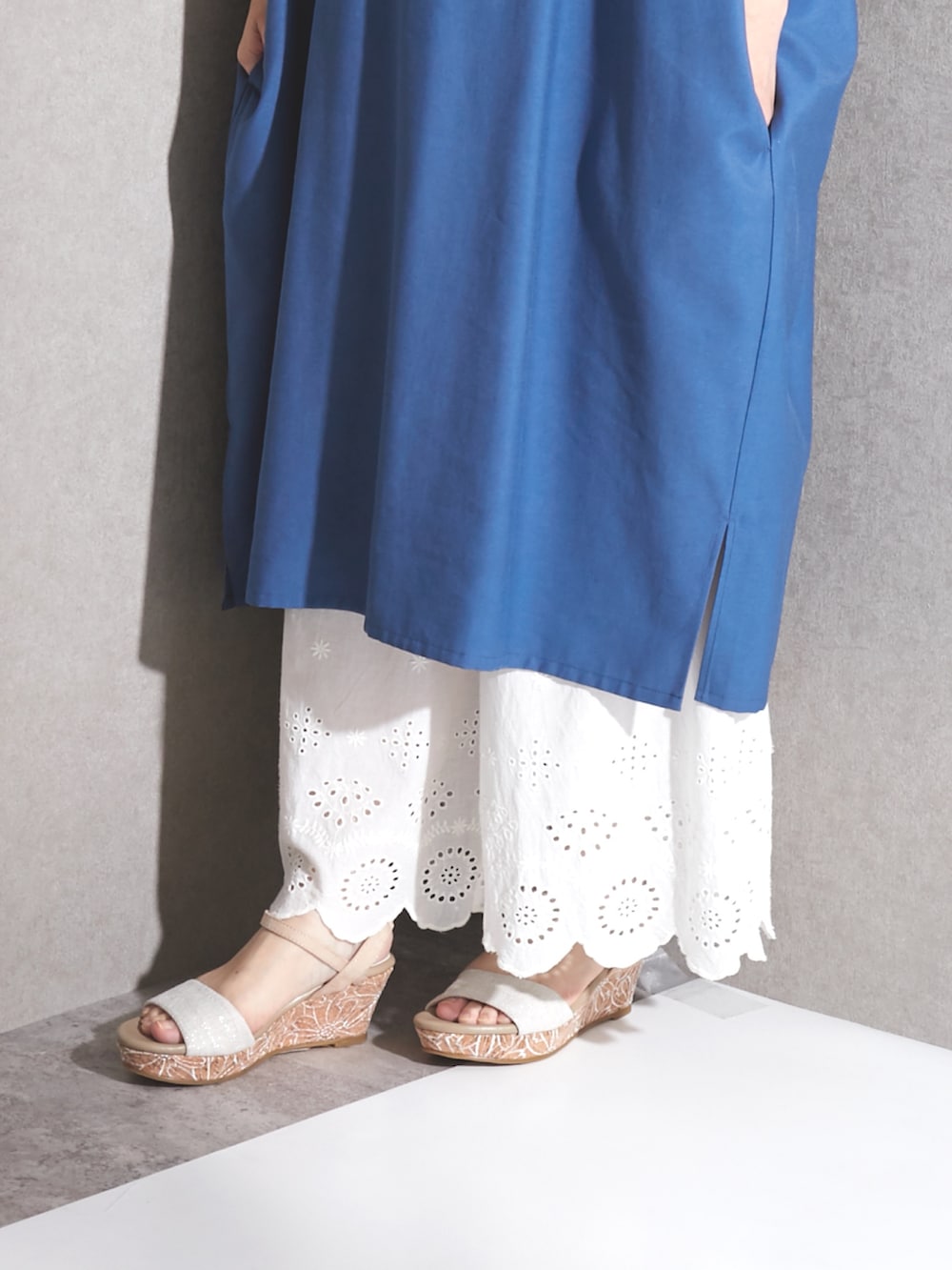 ブルー系のワンピース、ホワイト系のパンツ、ベージュ系のサンダルを着用したレディースの夏コーディネートの2枚目の写真