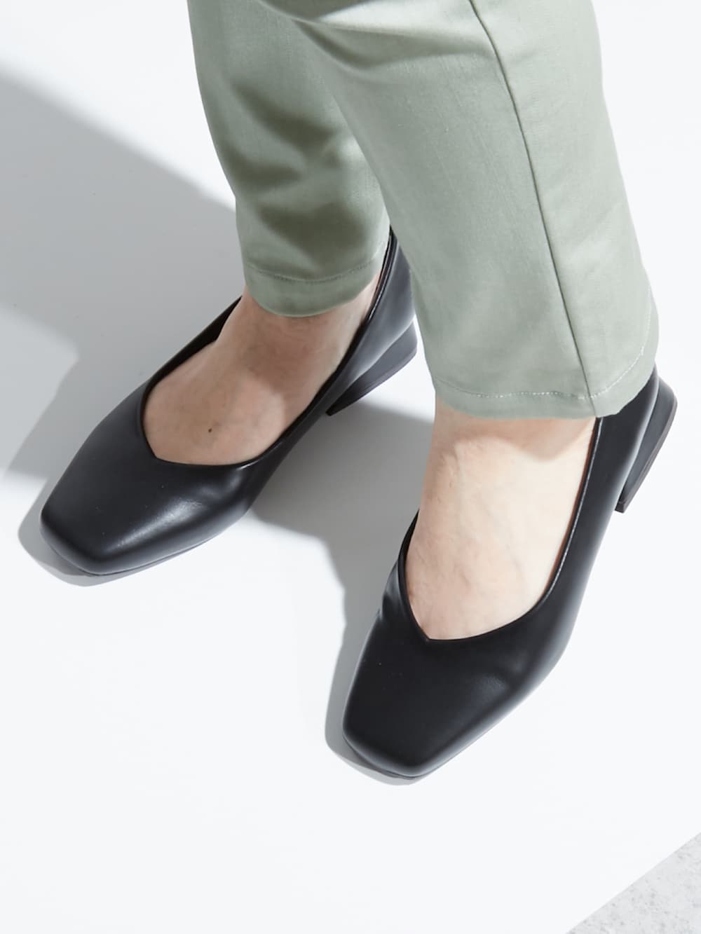 ブラック系のパンプス、ブラック系のシャツ/ブラウス、グリーン系のその他パンツを着用したレディースの夏コーディネートの3枚目の写真