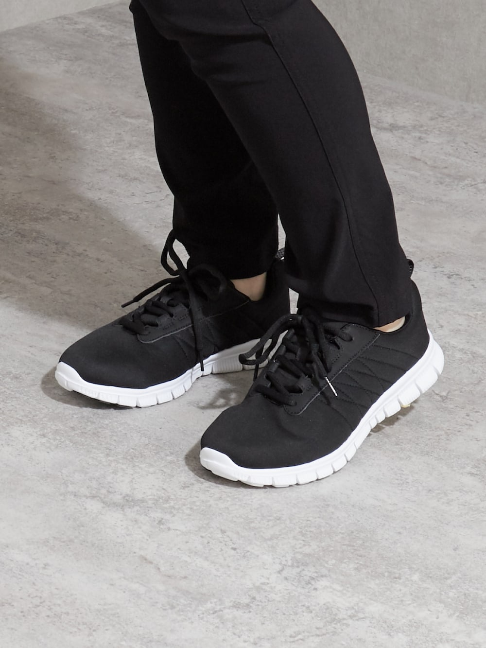 ブラック系のチュニック、ブラック系のパンツ、ブラック系のスニーカーを着用したレディースの夏コーディネートの2枚目の写真