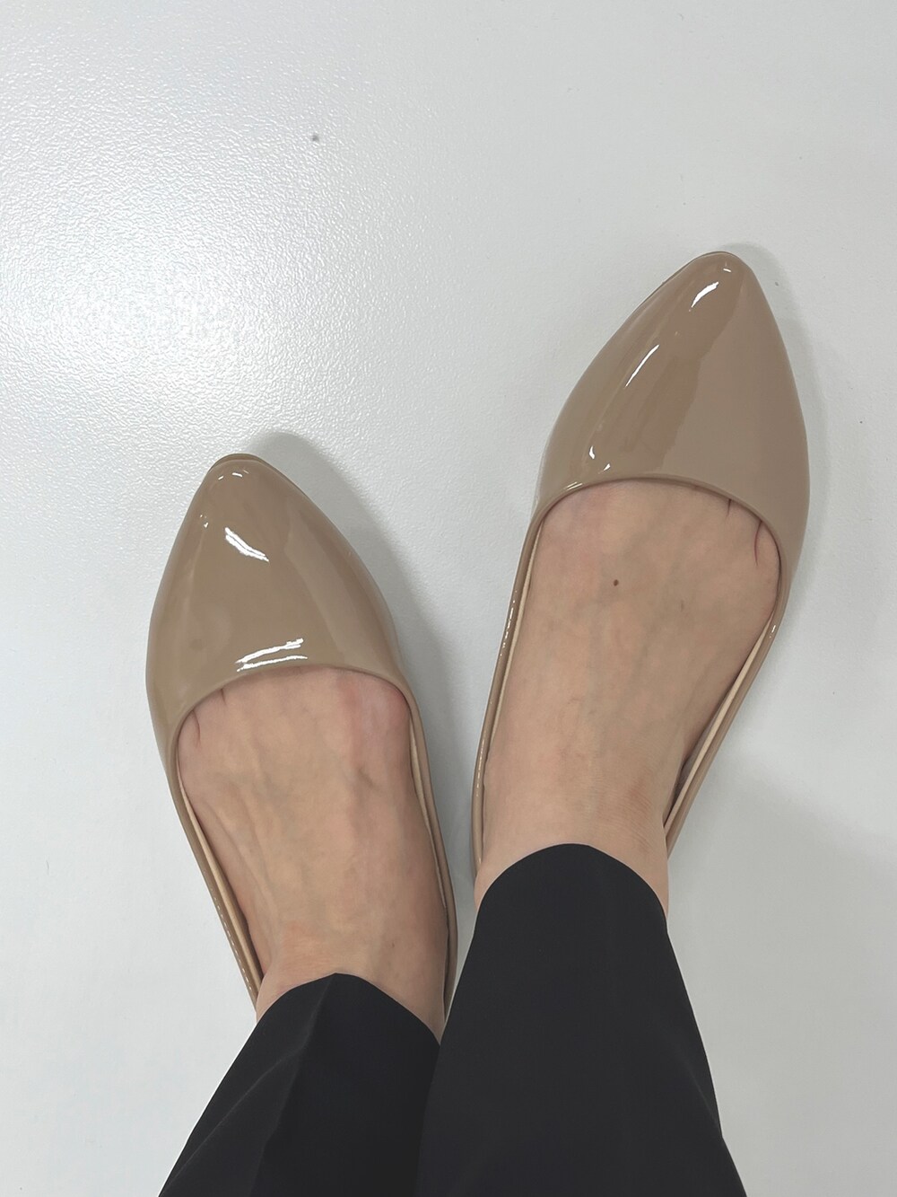 ベージュ系のTシャツ/カットソー、ブラック系のスーツセット、ベージュ系のパンプスを着用したレディースの夏コーディネートの3枚目の写真