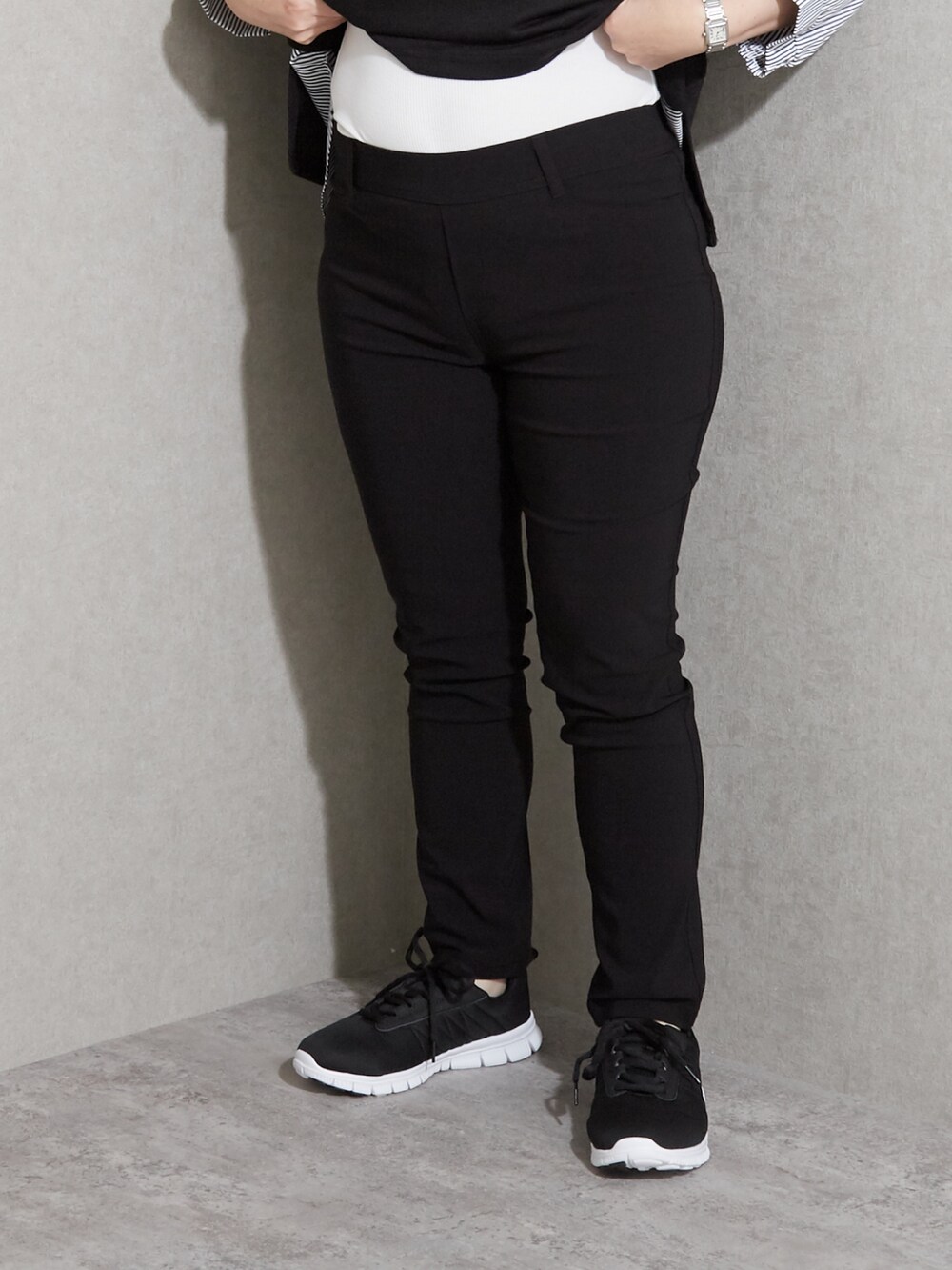 ブラック系のチュニック、ブラック系のパンツ、ブラック系のスニーカーを着用したレディースの夏コーディネートの4枚目の写真