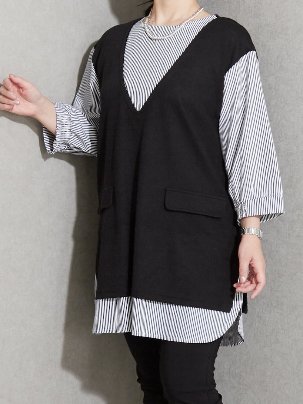 ブラック系のチュニック、ブラック系のパンツ、ブラック系のスニーカーを着用したレディースの夏コーディネートの3枚目の写真